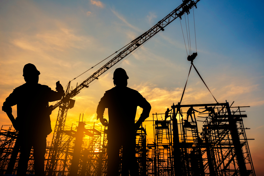 Construction site monitoring webcam showing worker silhouette at sunset